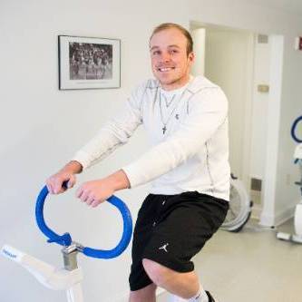 student riding exercise bike