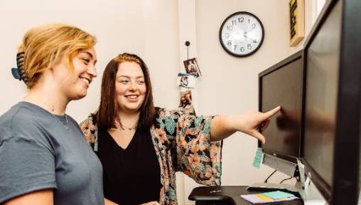 Two women looking at a computer monitor